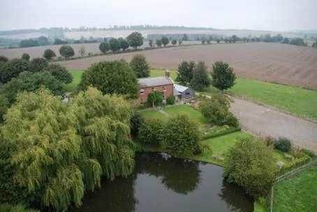 Suddene Park Farm from the air, with the house, pond and fields
