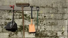 Yard tools hanging on a stone wall